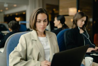 A woman with a computer sitting in an airport